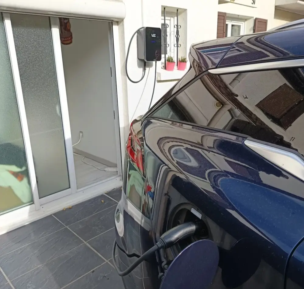Véhicule électrique en charge sur borne V2C en façade