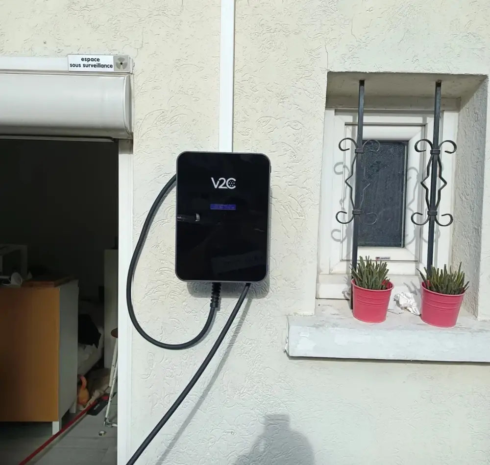 Borne V2C posée en façade à côté d'une fenêtre