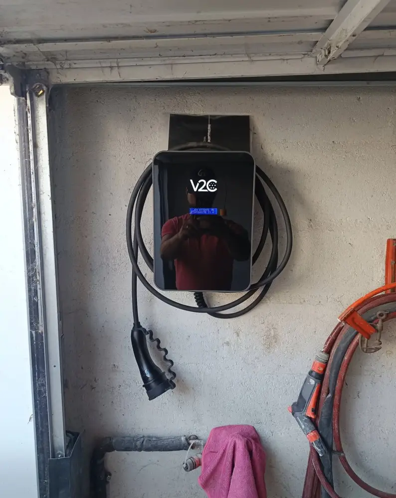 Borne V2C murale dans un garage avec câble enroulé