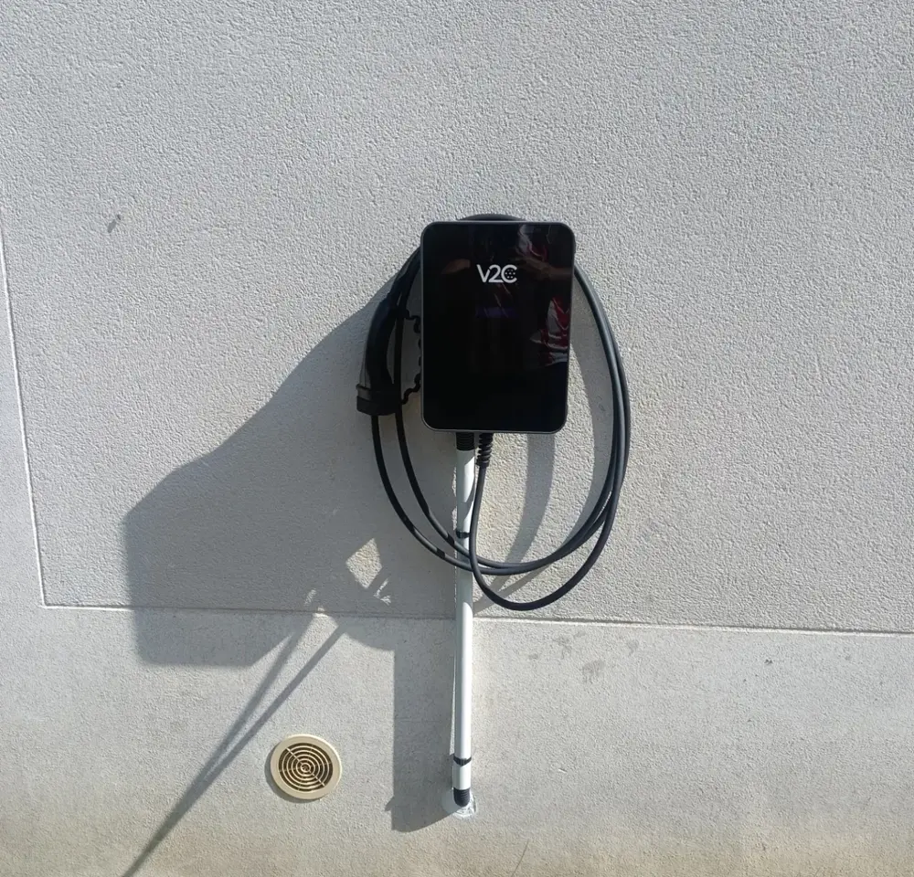 Borne V2C posée sur mur extérieur avec goulotte de protection