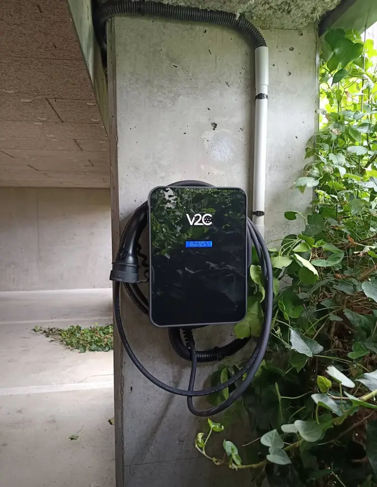 Borne V2C installée sur un pilier béton de parking couvert